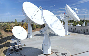 Networking technology shown through four ground antennas pointed at the sky